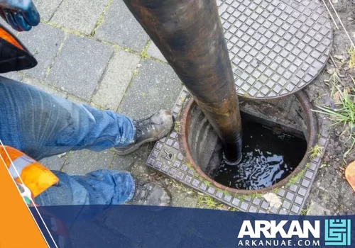 عامل من شركة تسليك مجاري في الشارقة يستخدم معدات حديثة لتنظيف وشفط مياه الصرف الصحي.