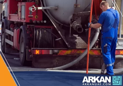 عامل من شركة سحب مجاري الشارقة يستخدم شاحنة متطورة لشفط وتنظيف البيارات باحترافية.