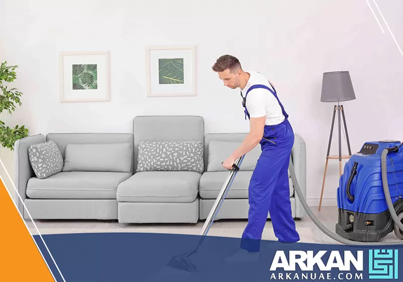 عامل شركة تنظيف فلل في عجمان يستخدم معدات تنظيف متطورة مثل المكانس المتخصصة لتنظيف الأرضيات والسجاد.