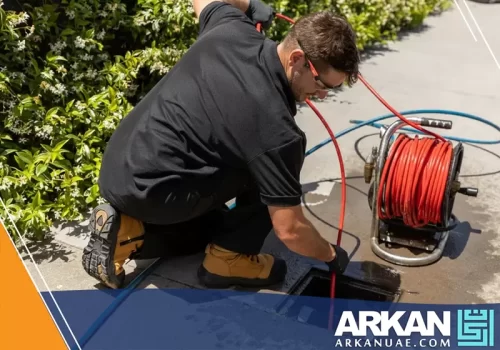 فني من شركة تسليك مجاري في رأس الخيمة أثناء استخدام معدات حديثة لتسليك المجاري في أحد المواقع.