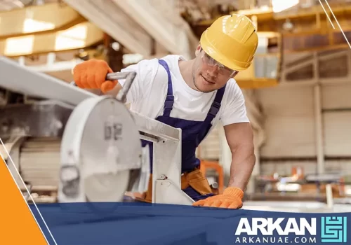 نجار غرف نوم في دبي وهو يستخدم معدات النجارة المتخصصة لتركيب قطع خشبية داخل ورشة النجارة.