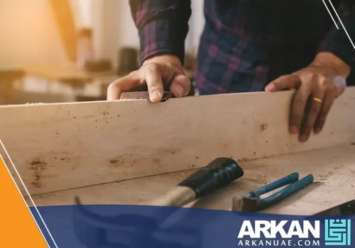 نجار في ورشة نجارة في دبي أثناء عمله على تجهيز قطعة خشبية باستخدام أدوات احترافية