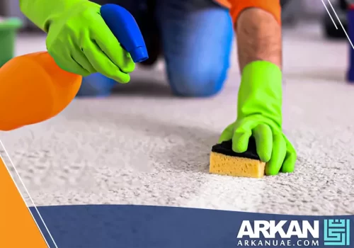 عامل مغسلة سجاد العين ينفذ تنظيفًا دقيقًا للسجاد باستخدام أدوات متخصصة لإزالة البقع وتحسين مظهر الألياف.