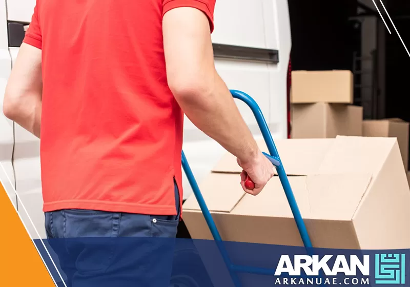 فني شركة نقل اثاث في ام القيوين يستخدم كراتين نقل العفش للحفاظ على الاثاث سليم قبل توصيله.